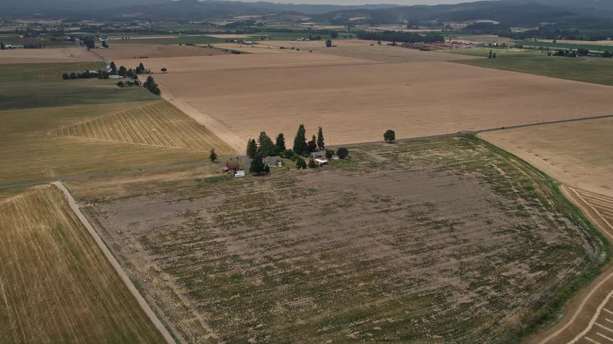 Aerial view approaching a farmhouse on a country road in Hillsboro Oregon during daytime in summer
