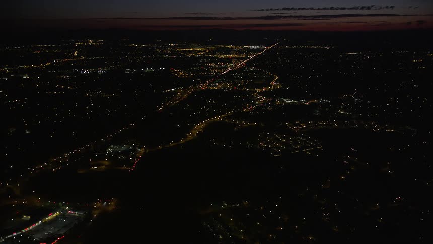  aerial footage flying over suburban neighborhoods at night approaching Highway 26 in Southwest Portland Oregon with light traffic and partly cloudy skies