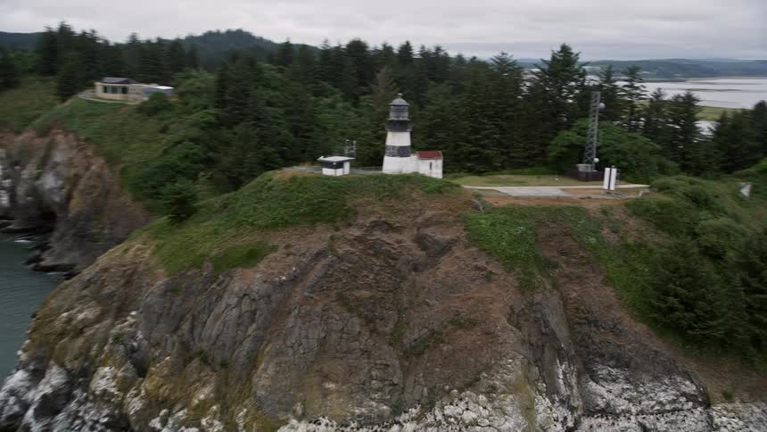 Tracking shot of the Cape Disappointment Light on coastal cliffs in Washington during a sunny day in summer