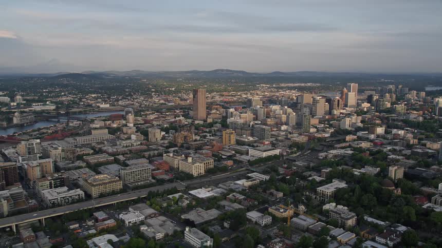 A stunning aerial view of downtown Portland Oregon during the summer with high-rise buildings the I-405 freeway and a beautiful sunset
