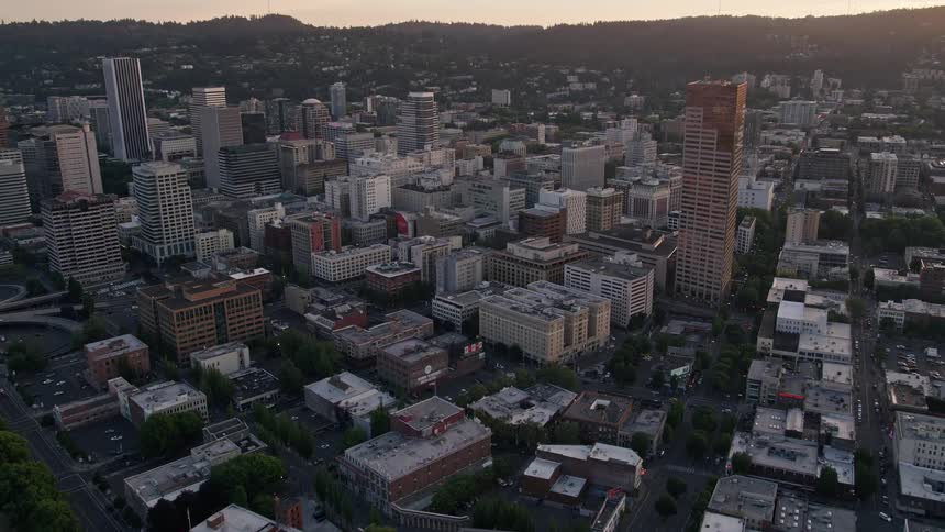 Approaching Burnside Bridge and US Bancorp Tower during sunset in downtown Portland Oregon with a view of the city river and skyscrapers