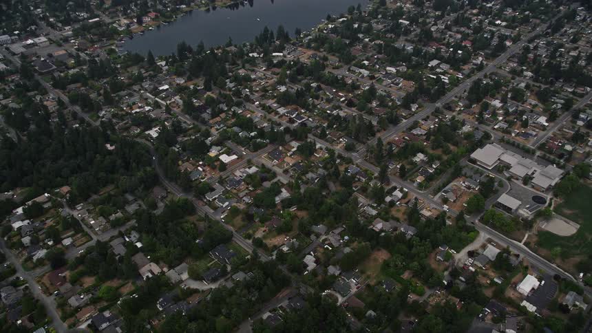 Aerial flyover and tilt of suburban homes near Lake Burien in Burien Washington during a sunny day in summer