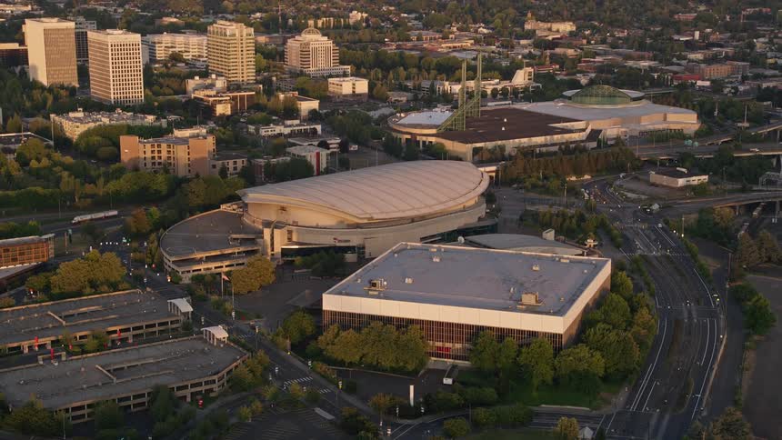 an aerial view of Rose Garden Arena and Memorial Coliseum at sunset showcasing the vibrant city of Portland Oregon with its high rises bridges and tranquil waterways