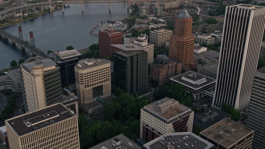 Approaching downtown Portland Oregon at sunset capturing the high-rise office buildings Terry Schrunk Plaza and the city park with a tilt down view