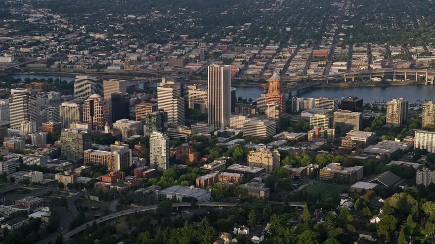 Taking flight over downtown Portland at sunset this aerial video showcases the city's high rise buildings the Willamette River and the vibrant metropolis below