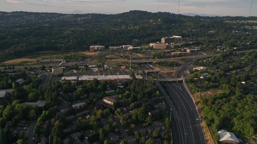 Aerial footage of sunset over Providence St Vincent Medical Center capturing the highway interchange in Southwest Portland Oregon during calm traffic