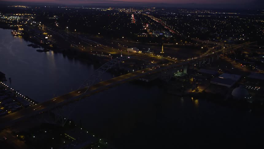 Aerial footage of flying over the Fremont Bridge in Downtown Portland Oregon during twilight with beautiful views of the city river and bridge