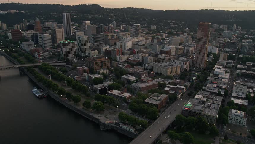Aerial footage of downtown Portland at twilight showcasing the city's high rises bridges over the river and the iconic White Stag building