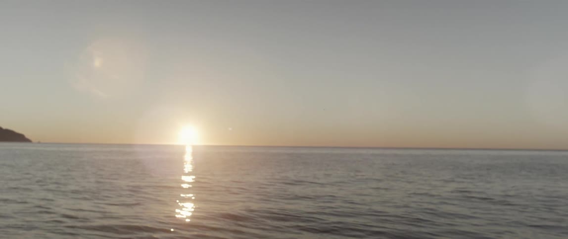 The sun is setting in the distance over the water