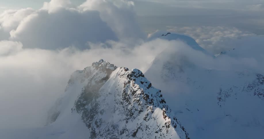 Aerial of a snow covered mountain during sunrise