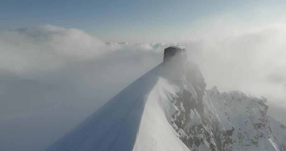 Aerial of a rocky mountain covered with snow at daytime