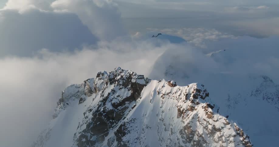 Aerial of a rocky mountain with snow during the day