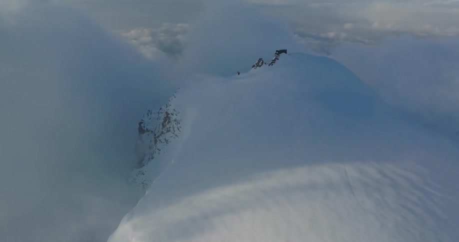 Aerial view of mountains at cloud level covered in snow