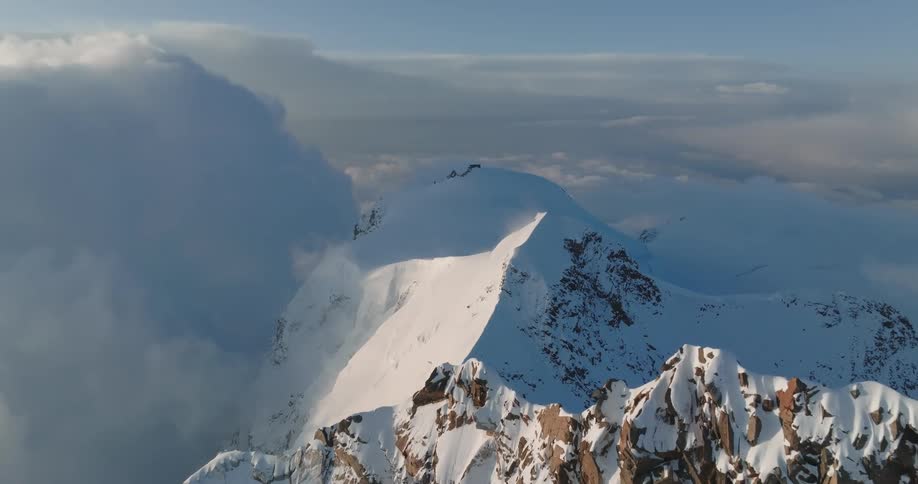 Aerial view of mountains at cloud level covered in snow