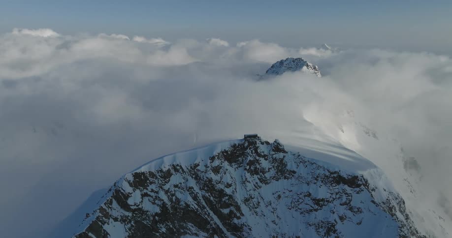 Aerial of a mountain covered in snow in daytime
