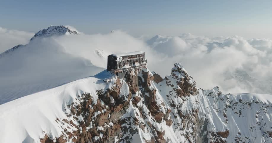 A house on top at the mountain peak covered in ice in the artic