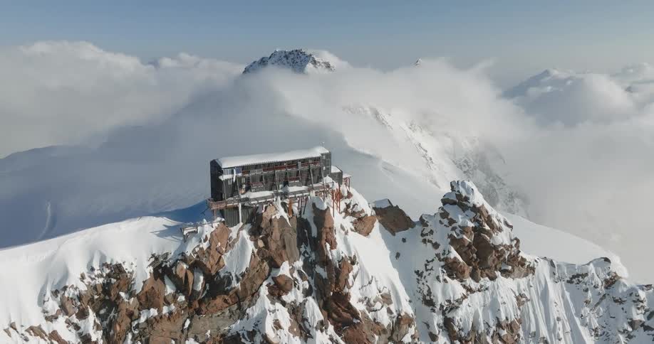 A house on top of the rocky mountain covered in snow in the artic