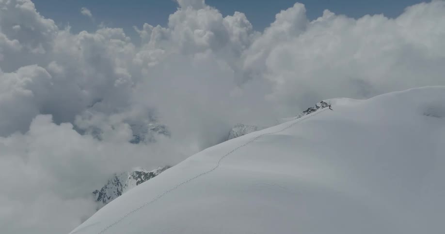 Aerial view of snowcovered mountains with a person hiking