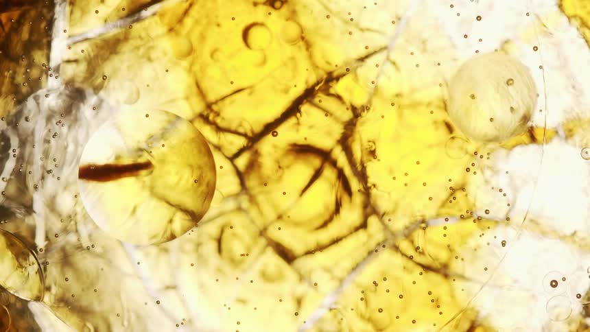 Bubble floating down a yellow bright liquid
