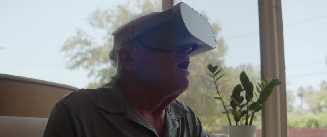 Elderly person using a virtual reality device and looking surprised
