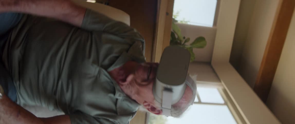 An elderly man interacts with virtual reality glasses