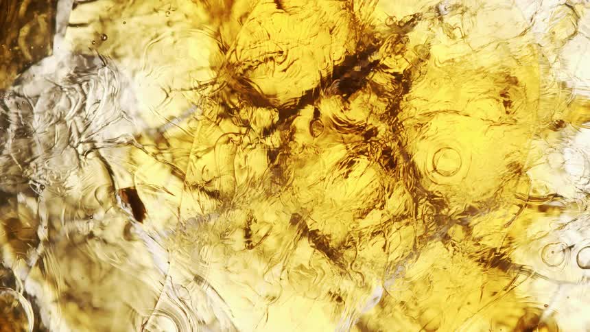 A golden liquid full of moving bubbles