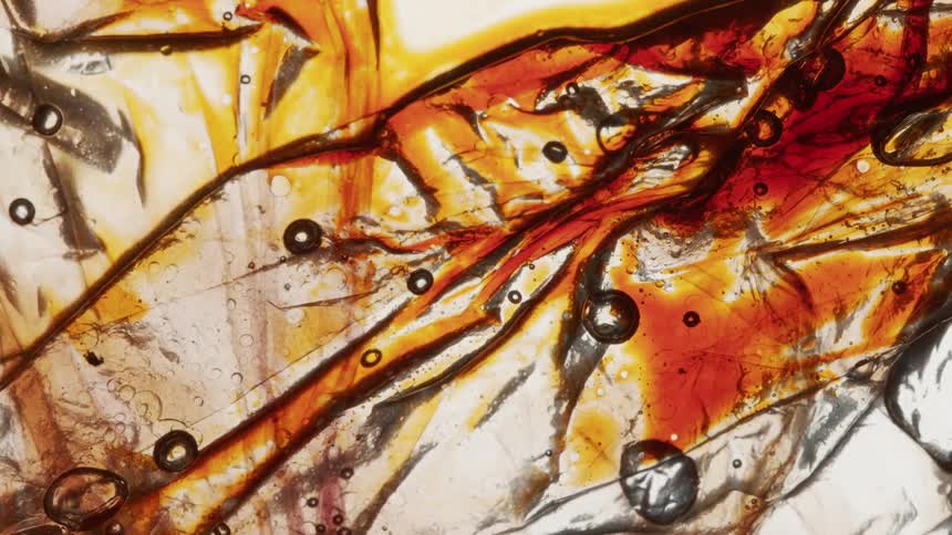 Yellow amber liquid ink strains flowing
