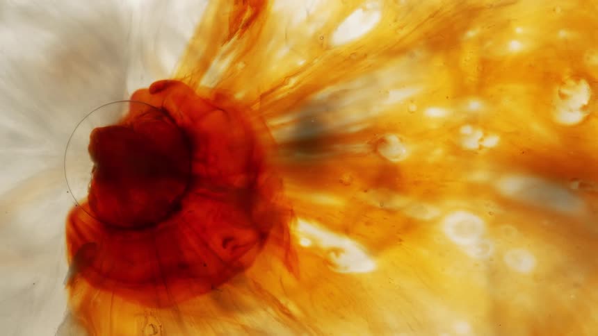 Extreme close up of orange and reddish liquid flowing in an abstract manner