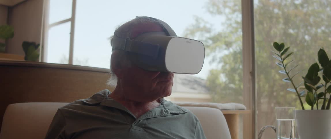 Elderly person using virtual reality glasses within an indoor environment
