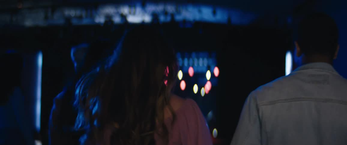 People walking backwards toward an entertainment venue