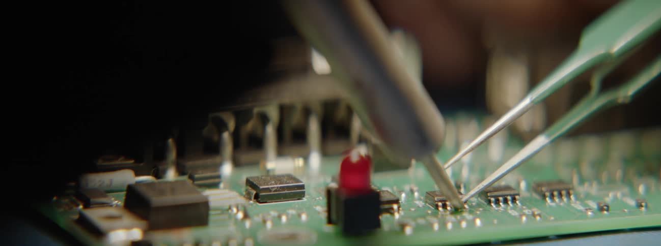 Closeup of tools performing reballing on a computer component
