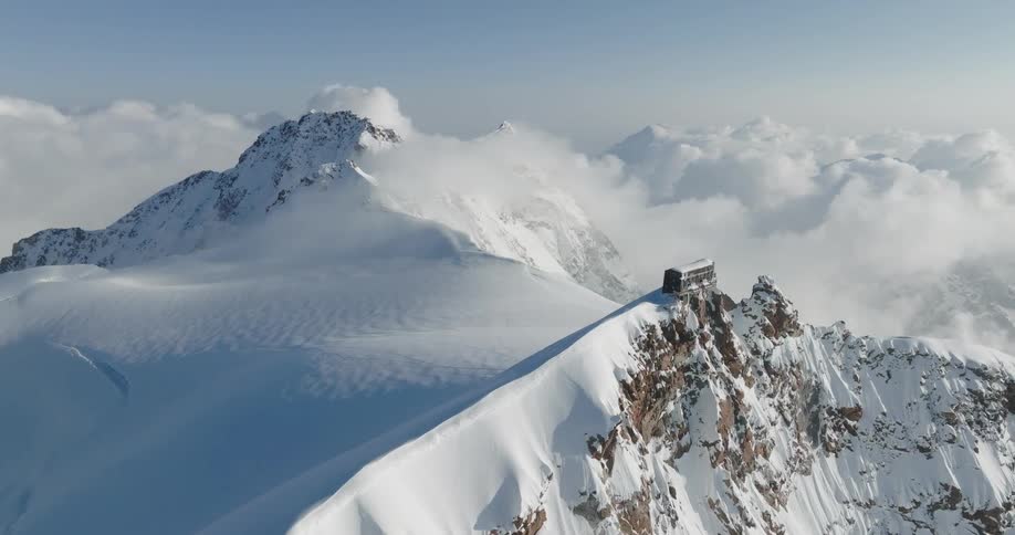 A building at the peak of a snow filled moountain