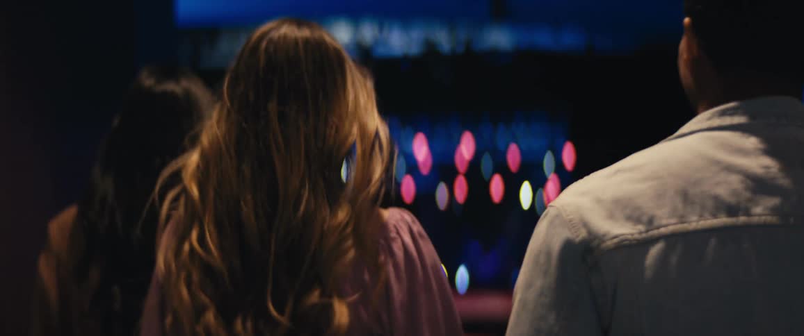 Back of black man and a white lady walking together at night