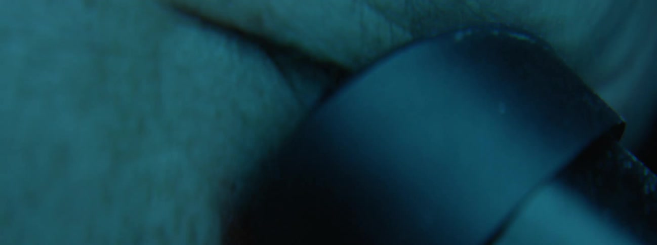 Man stares into eyepiece of microscope