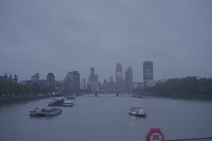 Boats parked on a lake with a bridge and skyscrapers in the background
