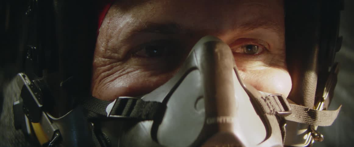 Man with mask on in a fighter jet on flight