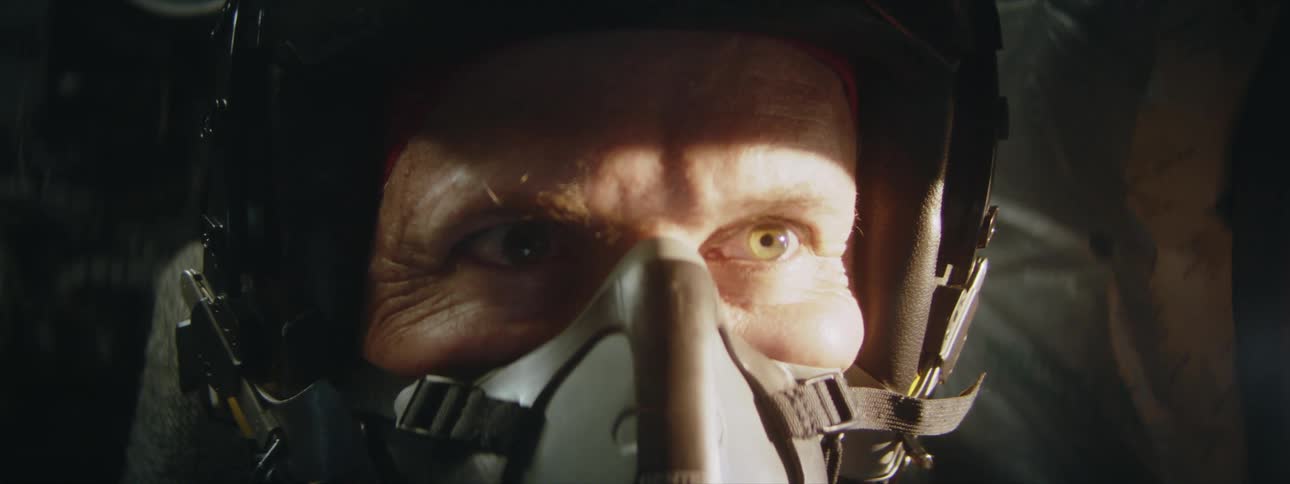 Portrait of a lighteyed pilot with a helmet and oxygenation on the head