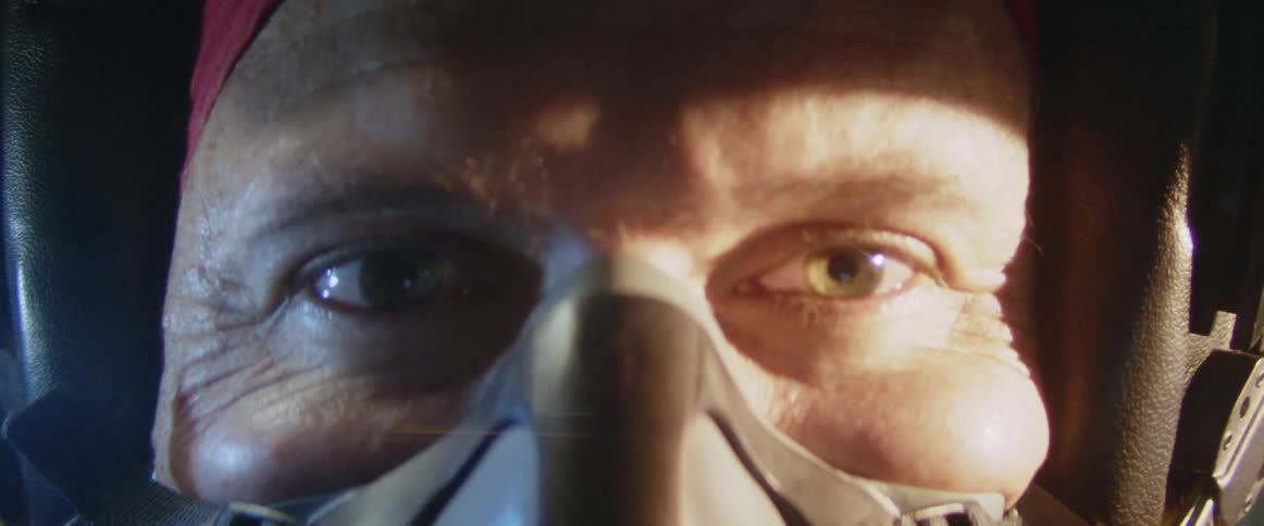 Portrait of a man wearing a pilots protective helmet with an oxygen mask and a happy facial expression