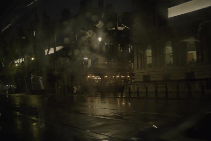 People and cars moving on a city road at night