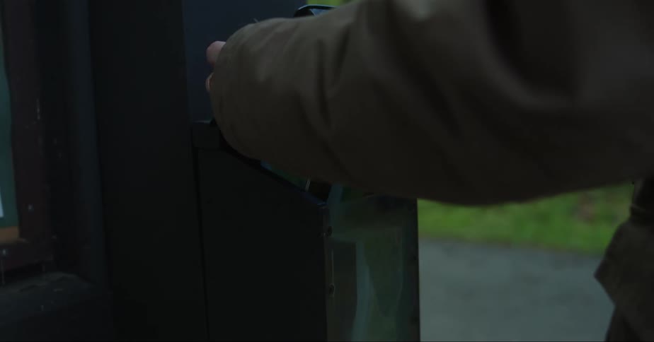 A person taking a piece of paper from a box on the wall with its hands