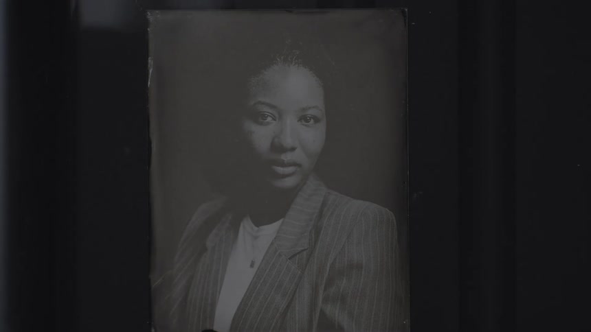 An old black and white portrait of a black woman inside a water container