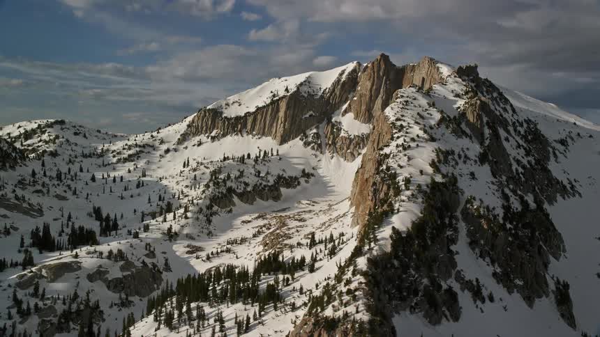 Aerial footage of Lone Peak in the snowy mountains of the Wasatch Range Utah showcasing the winter landscape and natural beauty of the southwest United States