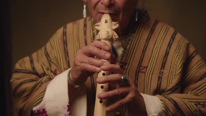Man plays carved wooden flute