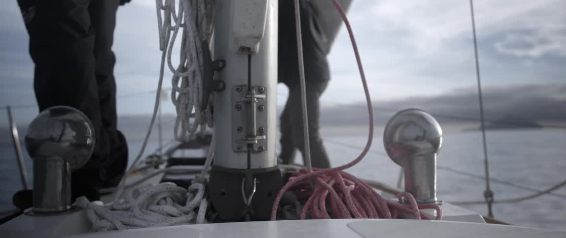 Two men are on a boat working on a cloudy day