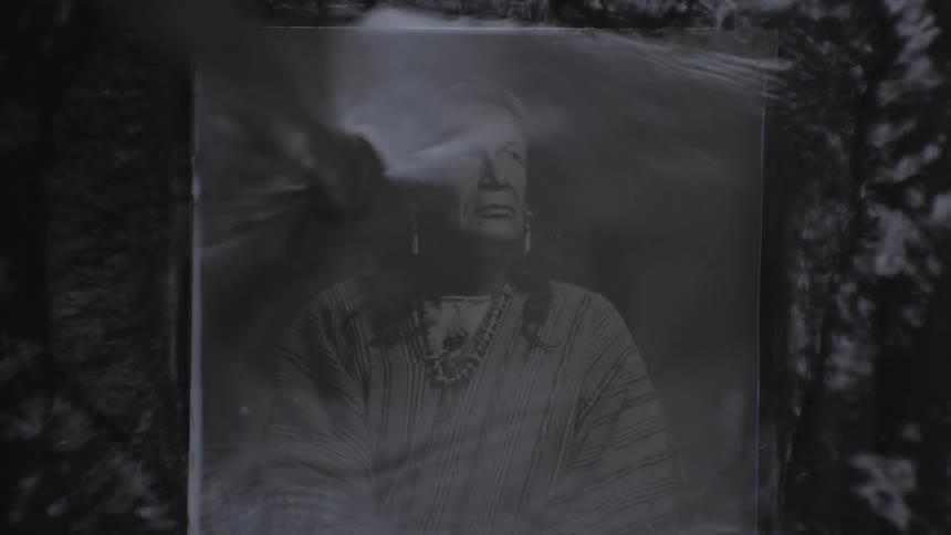 Liquid being poured onto a photograph of an indigenous person