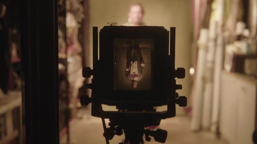 Close up of an upside down camera taking a photo of a woman