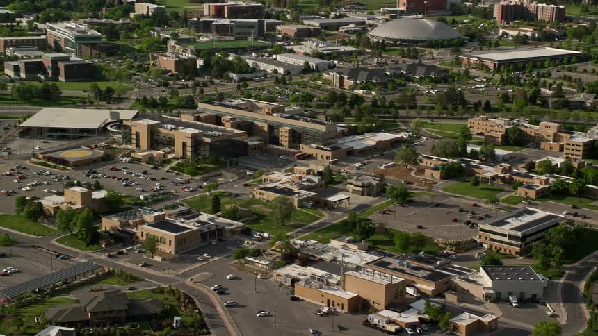 Aerial view of the University of Utah campus buildings passing by in Salt Lake City showcasing the sunny and vibrant atmosphere of a typical day on campus during the summer