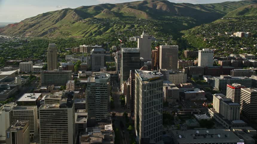  aerial footage of Salt Lake City's downtown area showcasing the convention center Utah State Capitol and stunning mountain views during a sunny summer day