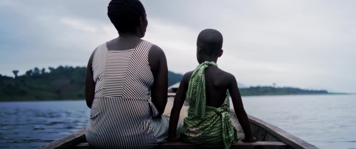 A woman sits next to her daughter on a boat in the water