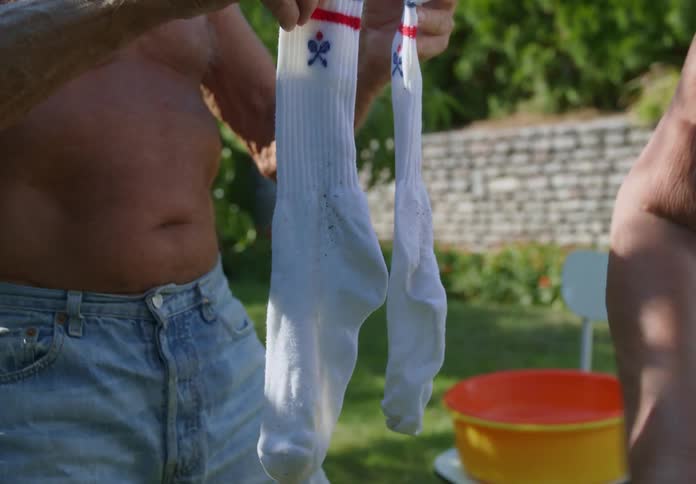 A couple hang laundry in the yard